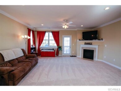 Spacious family room with plenty of natural light, new carpet, gas fireplace with granite surround, ceiling fan, crown molding, and door to back deck.