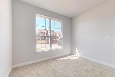 Spare room featuring carpet and baseboards