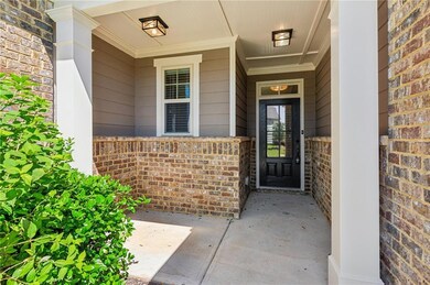Property entrance featuring a porch and brick siding