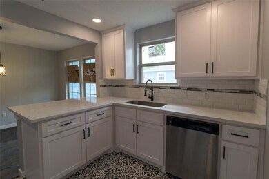 Look at this great kitchen! New peninsula with qauartz counters, new cabinets, new applicnaces! Trendy tiles on back splash and floor!