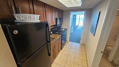 Kitchen with stone counters, a paneled ceiling, li