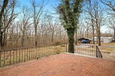 Brick patio over looking back yard.  Carport and s