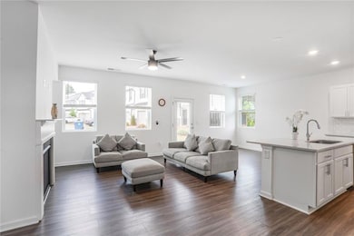 Living area with a ceiling fan, dark wood-style floors, a fireplace, recessed lighting, and baseboards
