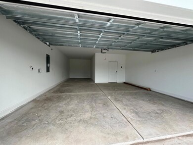 Garage with electric panel and a garage door opene
