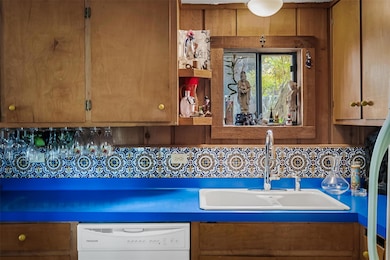 Kitchen featuring brown cabinetry, white dishwasher, backsplash, open shelves, and refrigerator