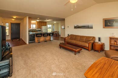 Living toward entry and kitchen with eating bar and built in  wine fridge.