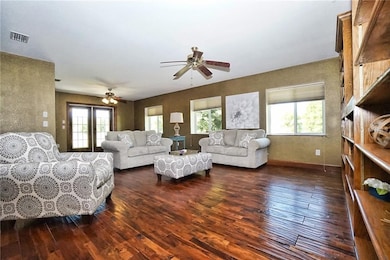 Living room with wood floors, bookcases and additi