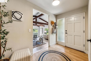 Foyer entrance featuring light wood-style flooring and baseboards