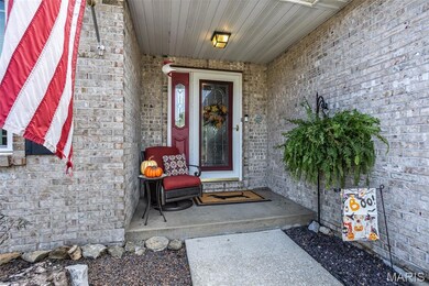 Doorway to property with brick siding and a porch