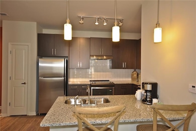 Kitchen featuring dark brown cabinets, stainless s