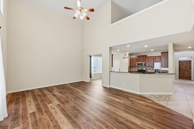 Unfurnished living room featuring light wood finished floors, a high ceiling, a ceiling fan, and recessed lighting
