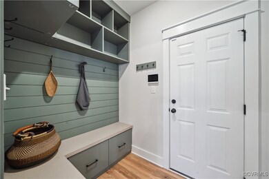 Mudroom with light wood-style flooring and baseboards