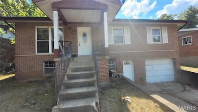 View of front of property featuring brick siding, concrete driveway, and a garage