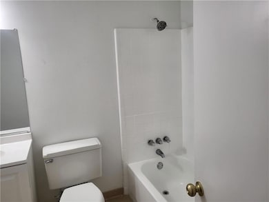 Bathroom featuring vanity, toilet, and washtub / shower combination