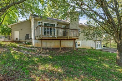Back of house with central AC, a patio, a yard, and a wooden deck