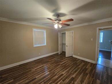 Unfurnished bedroom with a textured ceiling, crown