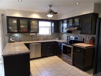 Updated kitchen with granite, glass tile backsplas
