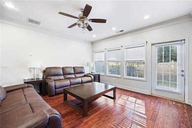 Living area featuring crown molding, dark wood-style flooring, recessed lighting, and a ceiling fan