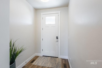 Doorway to outside featuring baseboards and wood finished floors