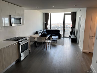 Kitchen with floor to ceiling windows, modern cabinets, appliances with stainless steel finishes, dark wood finished floors, and recessed lighting