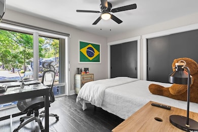 Bedroom with baseboards, a ceiling fan, dark wood-