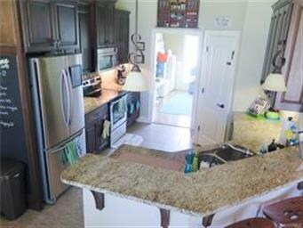 Kitchen features stainless appliances, slab granit