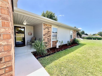 Entrance to property with brick siding and a lawn
