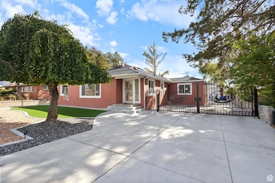 Single story home featuring a gate, stucco siding, and concrete driveway