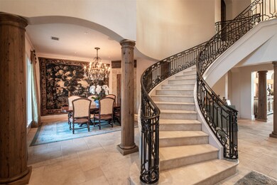 Custom, hand-forged wrought iron railings flank marble steps on the marvelous central staircase.