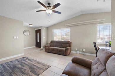 Living room featuring ceiling fan, baseboards, and
