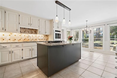 Kitchen with decorative backsplash, light stone co