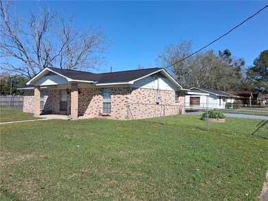 View of side of home featuring brick siding, fence