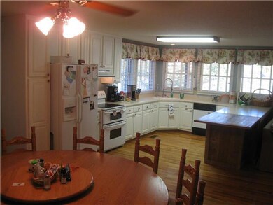 This large kitchen has windows overlooking the lake, corian countertops and custom reclaimed wood around the cabinetry and on an extended serving area.