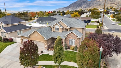 View of front facade featuring stucco siding, concrete driveway, a mountain view, stone siding, and a garage