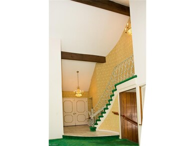 Marble foyer with iron railing and cathedral ceili