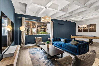 Living room featuring beamed ceiling, wood finished floors, pool table, and coffered ceiling