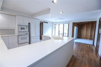All White Eat-In Kitchen with Hardwood Floors lead