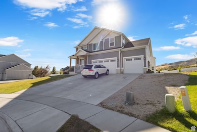 View of front of home featuring a mountain view, driveway, a garage, and a front yard