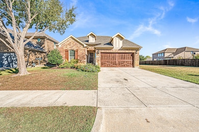 Traditional home featuring a shingled roof, driveway, brick siding, and an attached garage