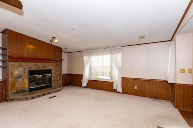 Unfurnished living room with wooden walls, a wains