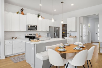 Kitchen with an island with sink, a sink, light w