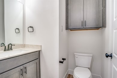 Half bath on 1st floor with vanity and wood finished floors