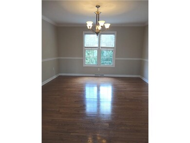 Dining Room. This fabulous dining room offers gleaming hardwood floors, a chair rail, crown molding and neutral wall colors.  The two oversized windows offer a great view of the manicured back lawn and woods.