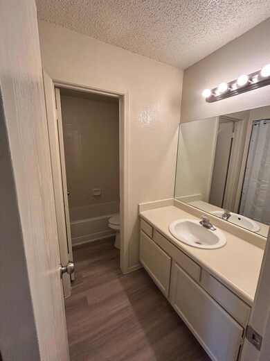 Full bathroom featuring wood finished floors, a t