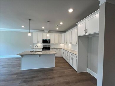 Kitchen with visible vents, an island with sink, a
