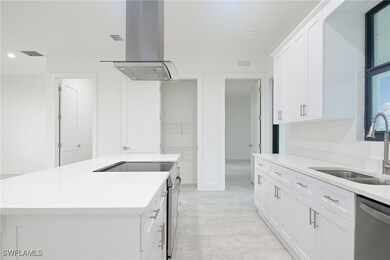 Kitchen with wall chimney exhaust hood, white cabi
