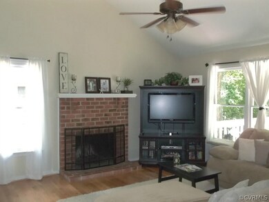 Living has cathedral ceiling, ceiling fan, brick f