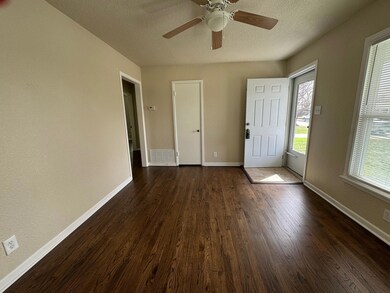 Foyer entrance with dark wood-style floors, visibl