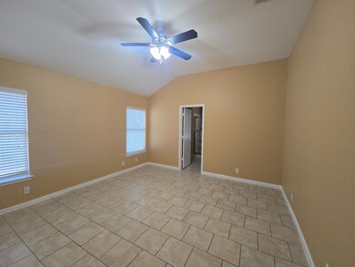 Unfurnished room featuring vaulted ceiling, light tile patterned floors, and ceiling fan