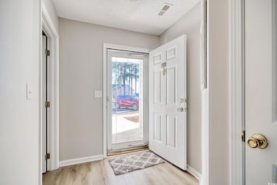 Entrance foyer with light hardwood / wood-style fl